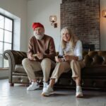 man and woman sitting on brown leather couch